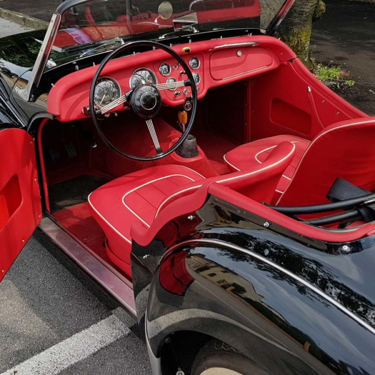 Triumph TR3 fitted with Bright Red Vinyl Interior Trim Panels, Leather Cappings, LeatherFaced Seat Covers, and a Bright Red Wool Carpet Set.