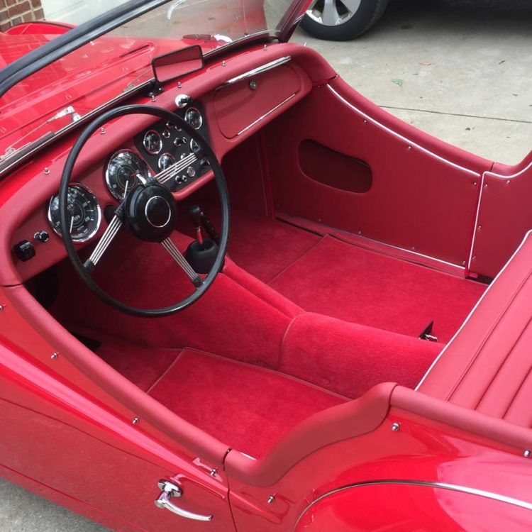 Triumph TR3A/B fitted with Cherry Red Vinyl Trim Panels, Leather Cappings, LeatherFaced Rear Seats, and Bright Red Wool Carpets.