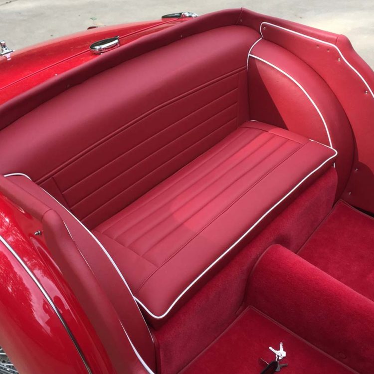 Triumph TR3A/B fitted with Cherry Red Vinyl Bulkhead Panel, Wheelarchs, Tonneau Cappings & Quarter Panels, LeatherFaced Rear Seats, and Bright Red Wool Carpets.