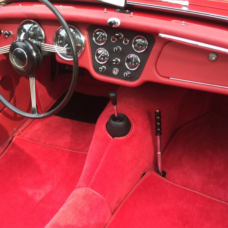 Triumph TR3A/B fitted with Cherry Red Vinyl Trim Panels and Dash Facia, Leather Cappings, and Bright Red Wool Carpets.