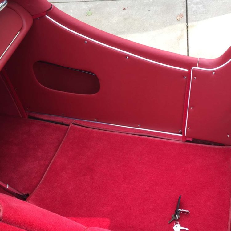 Triumph TR3A/B fitted with Cherry Red Vinyl Trim Panels, Leather Cappings, and Bright Red Wool Carpets.