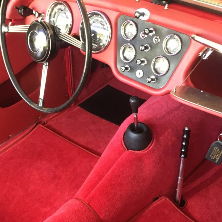 Triumph TR3A/B fitted with Cherry Red Vinyl Trim Panels, Leather Cappings, and Bright Red Wool Carpets.