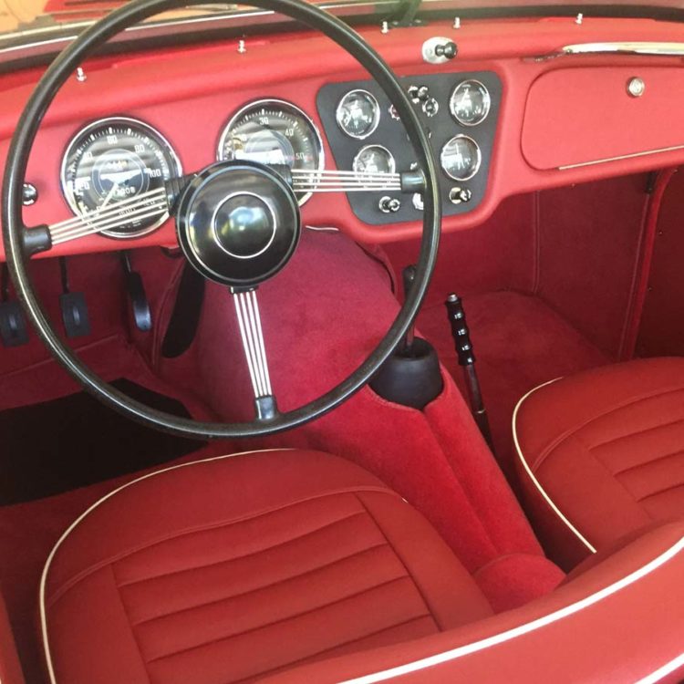 Triumph TR3A/B fitted with Cherry Red Vinyl Trim Panels, Leather Cappings, LeatherFaced Front Front Seat Covers, and Bright Red Wool Carpets.