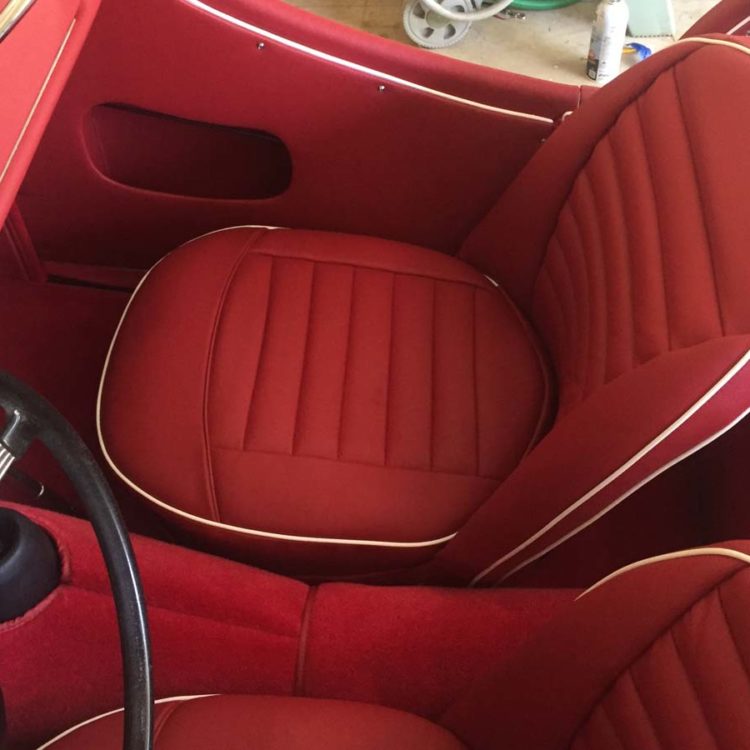 Triumph TR3A/B fitted with Cherry Red Vinyl Trim Panels, Leather Cappings, LeatherFaced Front & Rear Front Seat Covers, and Bright Red Wool Carpets.