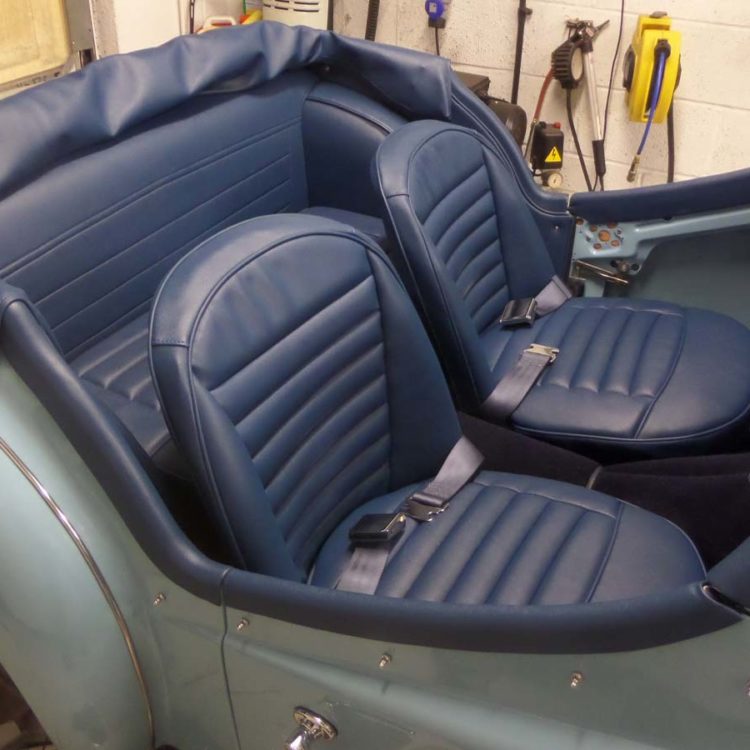 Triumph TR3A/B fitted with AH Blue Vinyl Interior Trim Panels, Hood Frame Cover, Front & Rear Seat Covers, and Dark Blue Wool Carpets.