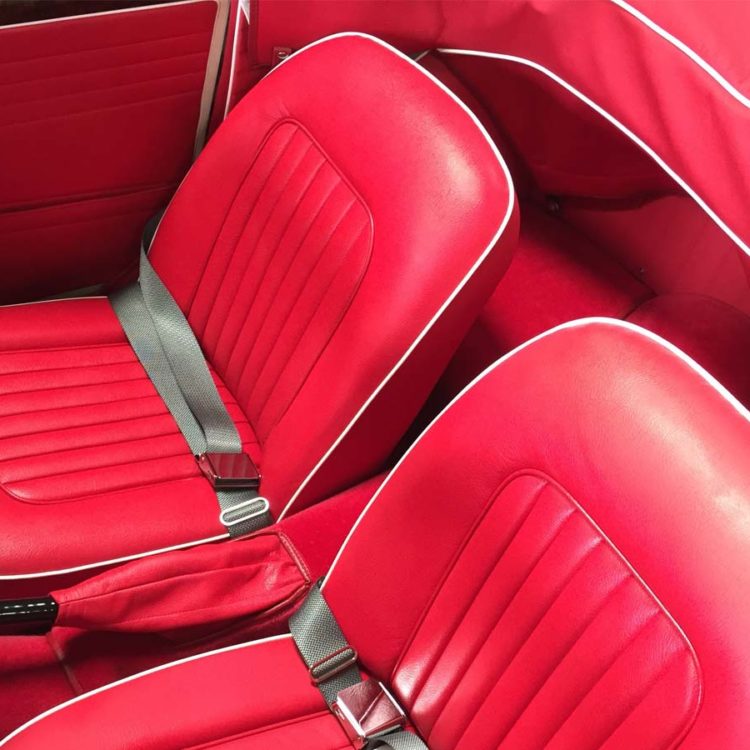 Triumph TR4A fitted with Bright Red Interior Trim Panels, Leather Seat Covers, Hood Frame Cover, and Bright Red Wool Carpets.