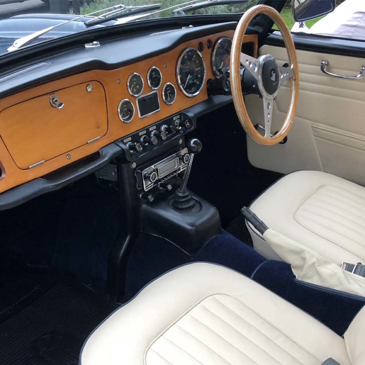 Triumph TR4A fitted with Parchment Leather Door Panel Trims, Front Seat Covers, and Dark Blue Wool Carpets.