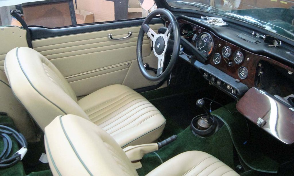 Triumph TR5 / TR250 fitted with Stone Vinyl Interior Trim Panels, Front Seat Covers and Dark Green Nylon Carpets.